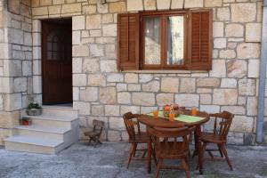 a wooden table and chairs in front of a building at House Toncica in Dol