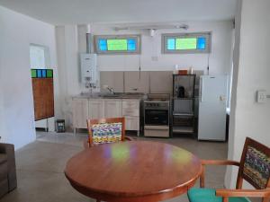 サン・フランシスコにあるDepartamento Susy San Franciscoの木製のテーブルとテーブルと椅子のあるキッチン