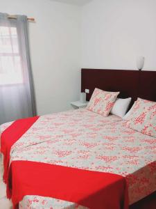 een slaapkamer met een bed met een rood-witte deken bij La rosa, vivienda vacacional in Breña Baja