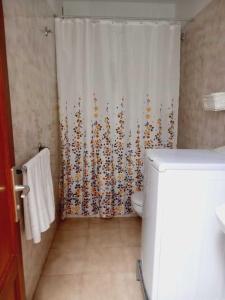 een badkamer met een douchegordijn en een toilet bij La rosa, vivienda vacacional in Breña Baja