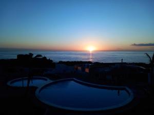 een zonsondergang boven de oceaan met een zwembad bij La rosa, vivienda vacacional in Breña Baja