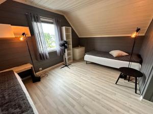a small room with a bed and a window at Koselig leilighet strandnær opplevelse! in Grimstad
