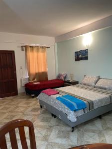 Un dormitorio con dos camas y una silla dentro. en Gloria Apart Oran, en San Ramón de la Nueva Orán