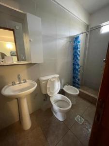 Un baño con inodoro, lavabo y ducha. en Gloria Apart Oran, en San Ramón de la Nueva Orán