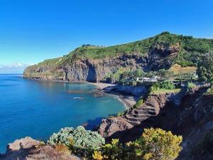 a view of a beach on a rocky coast at Moradia Rústica Jardim in Caloura