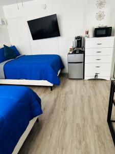a bedroom with two beds and a tv and a dresser at Superior beach studio with Pool Access and free parking in Daytona Beach