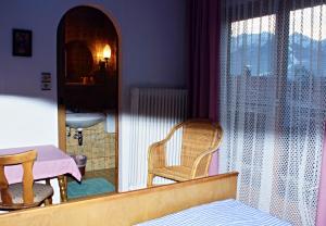 a bedroom with a mirror and a chair and a table at Pension Alpentraum in Zell am See