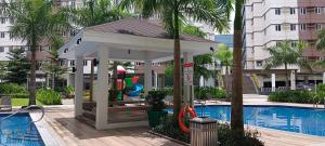 a gazebo with a playground next to a pool at Hope Residences by YsaRiCh Haven in Trece Martires