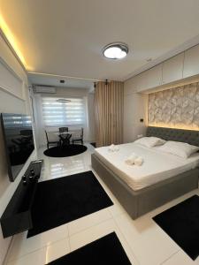 a bedroom with a large bed and a television at A'dors Apartments in Skopje