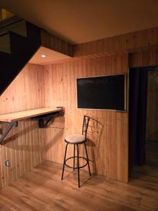 eine Bar mit einem Hocker in einem Raum mit einem Fernseher in der Unterkunft Rustic Hideaway in Nauwigewauk