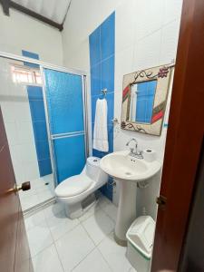un bagno blu e bianco con un water e un lavandino di Hostal Coco River Minca a Minca Altre 26 foto