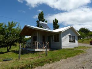 uma pequena casa branca com telhado solar em Agroturismo Coñico em Quilquico