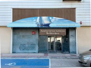 un edificio con una puerta de cristal con un velero en él en Apartamentos Turisticos Mediterraneo, en Cartagena