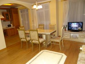 ein Esszimmer mit Tisch und Stühlen und einem Fernseher in der Unterkunft Luxury Versailles Apartments Center Opera in Burgas City