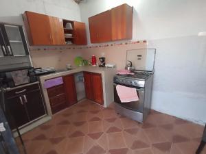 a kitchen with wooden cabinets and a stove top oven at El Capricho II Paracas in Paracas
