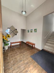 una stanza vuota con due panche e scale di MarBelo Bertioga Apartamentos e Suítes a Bertioga