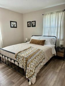 a bedroom with a bed with white sheets and a window at The Sunset Cottage - Wyoming by Primo Management in Rock Springs