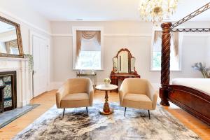 a bedroom with a bed and two chairs and a mirror at Nevis Estate Boutique Hotel in Perth +67 photos