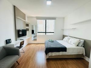 a bedroom with a bed and a couch and a television at Bexp Spaces | Bethaville - Barueri in Barueri
