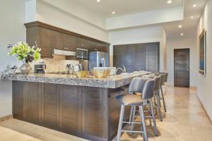 une cuisine avec un grand comptoir et des tabourets de bar dans l'établissement 3BR Ground Floor - Resort Access - Private Beach, à Los Médanos Partidos