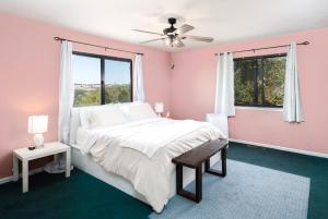 a pink bedroom with a large bed and windows at Breathtaking view of the Hills with HotTub, Pool and Pool Table in Marble Mountain