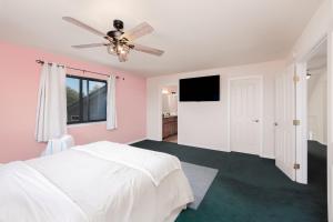 a bedroom with a white bed and a ceiling fan at Breathtaking view of the Hills with HotTub, Pool and Pool Table in Marble Mountain