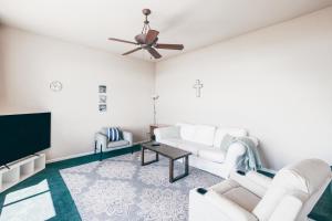 a living room with white furniture and a flat screen tv at Breathtaking view of the Hills with HotTub, Pool and Pool Table in Marble Mountain