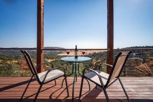 a table with two chairs and a glass of wine on a deck at Breathtaking view of the Hills with HotTub, Pool and Pool Table in Marble Mountain