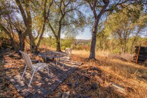 a table and chairs on a stone walkway with trees at Breathtaking view of the Hills with HotTub, Pool and Pool Table in Marble Mountain