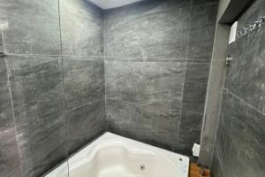 a bathroom with a bath tub in a tiled room at Apto 10, Temático Veuve Clicquot com Jacuzzi na Morada do Ganso in Bombinhas +16 photos