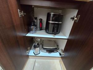 a cabinet with a coffee maker and a blender in it at Hermoso Departamento Equipado por Días in Arica