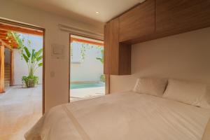 a bedroom with a bed and a sliding glass door at CASA EMMA HOTEL Boutique in Cartagena de Indias