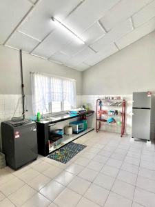a kitchen with a sink and a refrigerator in it at Bed's Homestay Kluang in Kluang