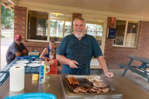 a man standing at a table with a tray of meat at NRMA Dubbo Holiday Park in Dubbo +27 photos