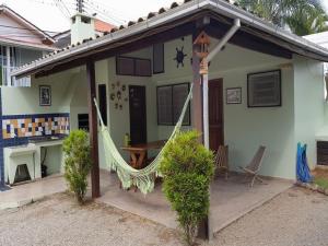 a house with a hammock in front of it at Residencial do Tchê in Florianópolis