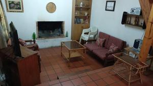 Casa Quincho en el Bosque في بونتا دل إستي: غرفة معيشة مع أريكة ومدفأة