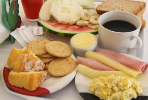 a plate of breakfast foods with a cup of coffee at Casa da Lua Buzios in Búzios