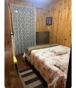 a bedroom with a bed and a window at Casa de madeira 262 in Campos do Jordão