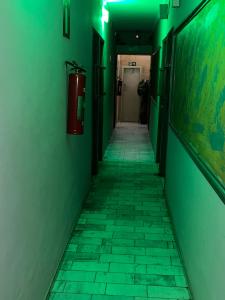 an empty hallway with green walls and a fire hydrant at Belo Motel in Belo Horizonte +3 photos