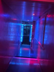 a hallway with blue and red lights in a room at Belo Motel in Belo Horizonte