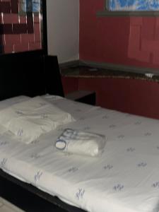 a bed with white sheets and blue writing on it at Belo Motel in Belo Horizonte
