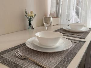 a table with two plates and a fork and glasses at Claire's Empire in Lapu Lapu City +10 photos