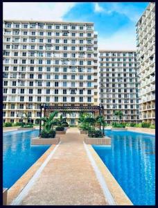 a large apartment building with a large pool of water at Claire's Empire in Lapu Lapu City