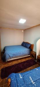 ein Schlafzimmer mit einem Bett mit blauen Laken und blauen Kissen in der Unterkunft Casa interior cercana aeropuerto in Santiago