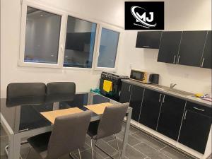 a kitchen with a table and chairs in a room at MJ Apartment Complex in Sanchaba