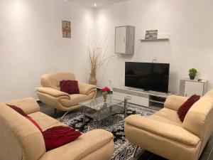 a living room with three chairs and a television at MJ Apartment Complex in Sanchaba