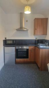 a kitchen with wooden cabinets and a stove top oven at Studio Flat in Nottingham