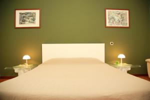 ミラノにあるBilocale Indipendenteのベッドルーム(白い大型ベッド、ランプ2つ付)