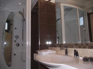 a bathroom with a sink and a shower with a mirror at Park Hotel Cilento in Marina di Camerota