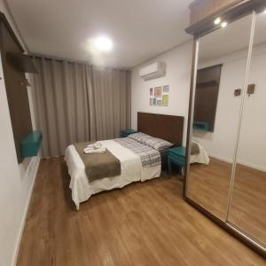 a bedroom with a bed and a sliding glass door at Apartamento aconchego in Gramado